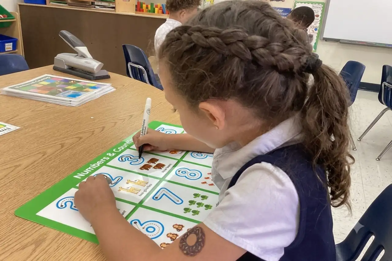 A child tracing numbers during a classroom learning activity at Horizons Childcare & Learning Center.
