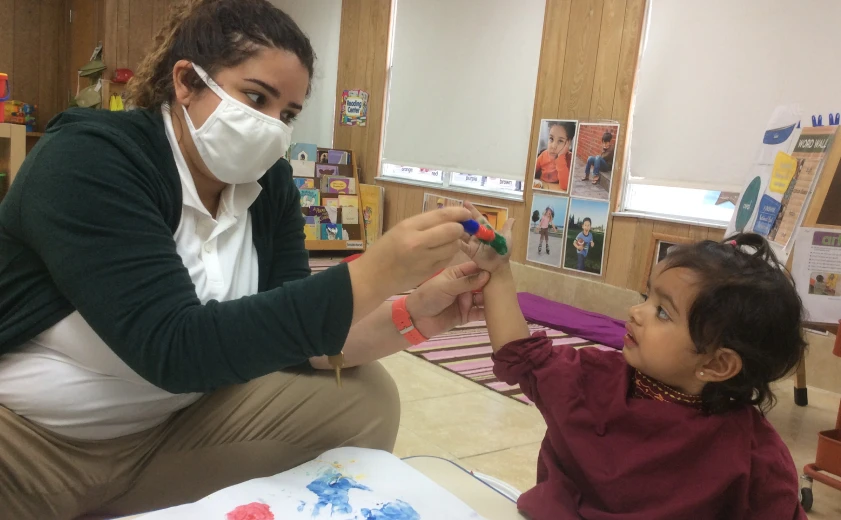 Teacher guiding a child during a classroom learning activity in Orlando.