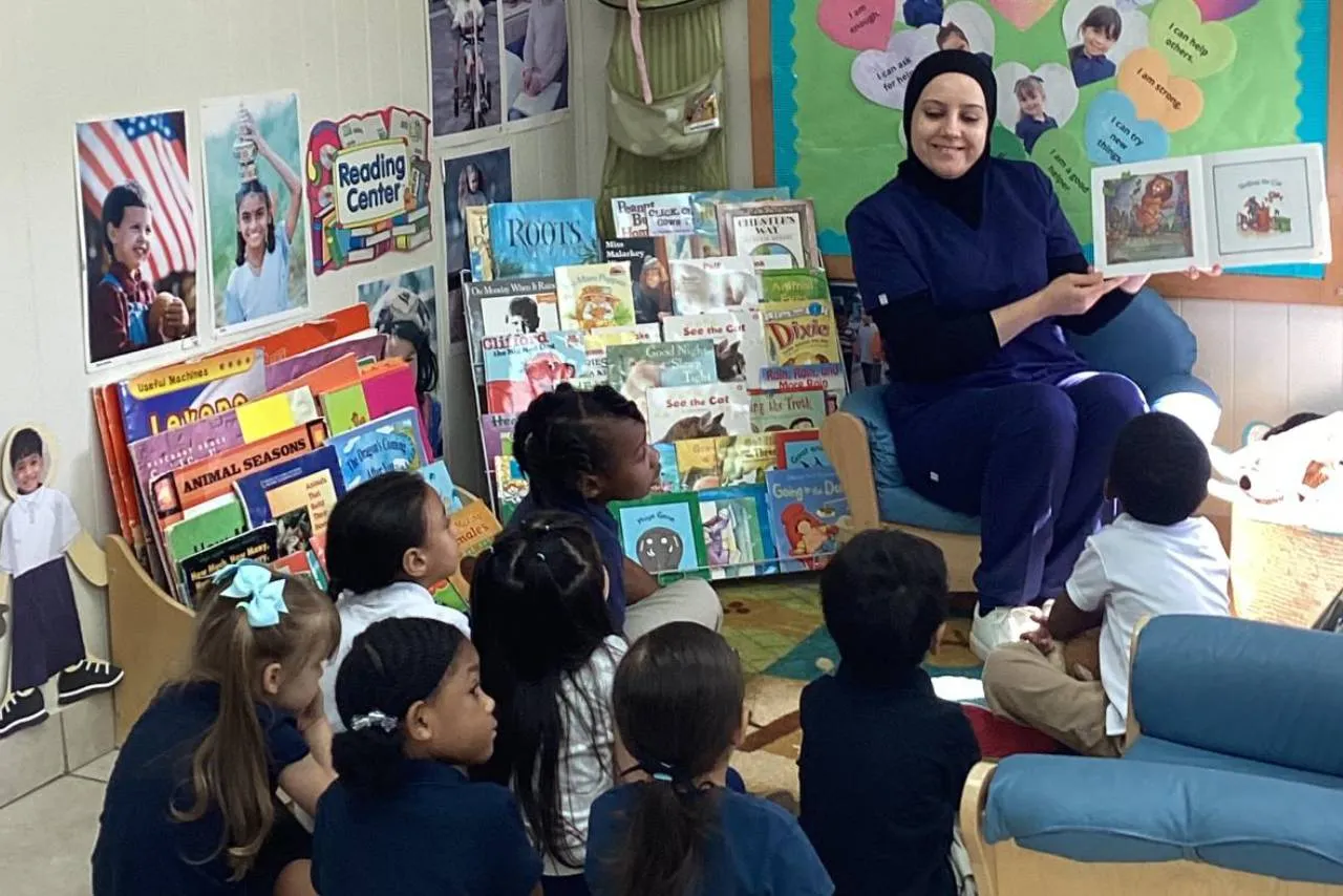 Preschoolers in Horizons uniforms taking part in circle time with their teacher in Orlando.